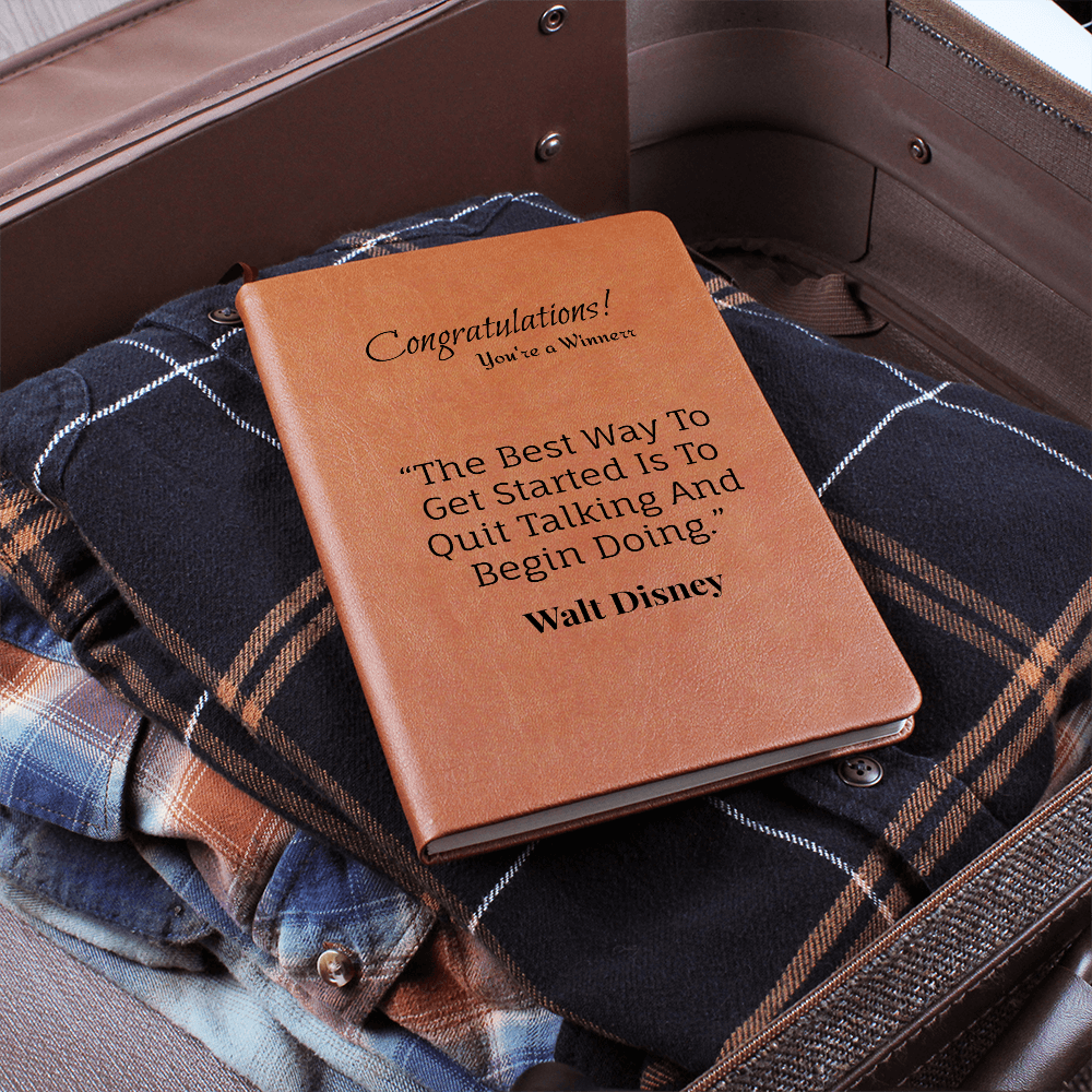 Brown journal resting on a checked jacket inside an open suitcase