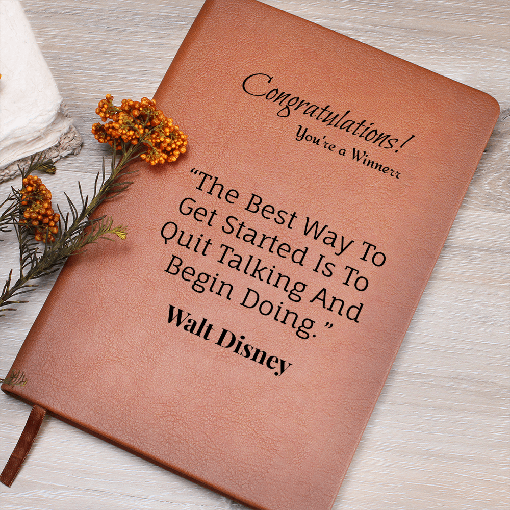 Brown quote journal with Congratulations message styled with orange flowers on a wooden surface