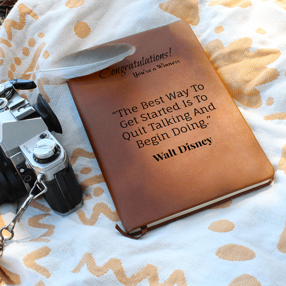 Brown Walt Disney quote journal with a camera, feather and patterned fabric