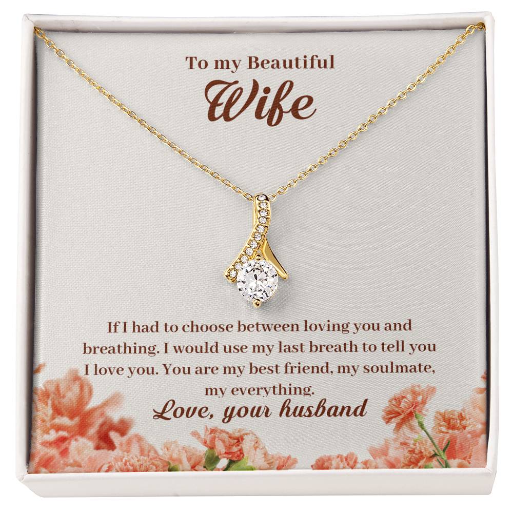 Gold-tone ribbon pendant necklace displayed on a floral message card addressed to a beautiful wife.