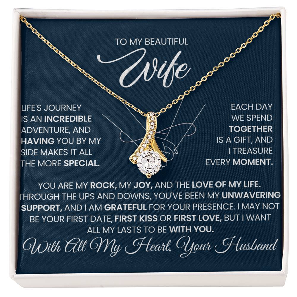 Gold-tone ribbon pendant necklace displayed on a navy wife message card