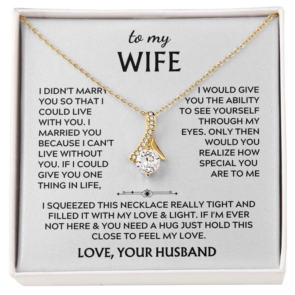 Gold-tone ribbon pendant necklace displayed across a printed wife message card.