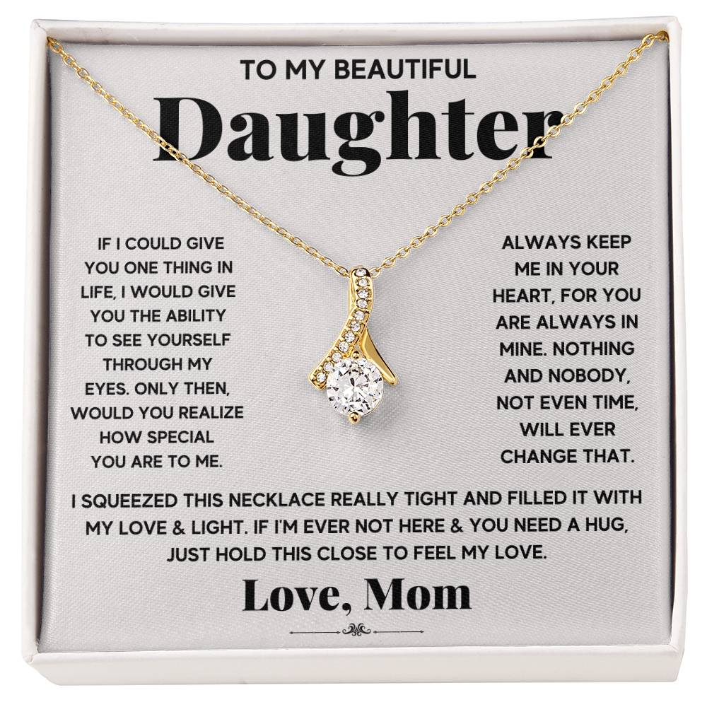 Gold ribbon pendant necklace displayed on a printed daughter message card
