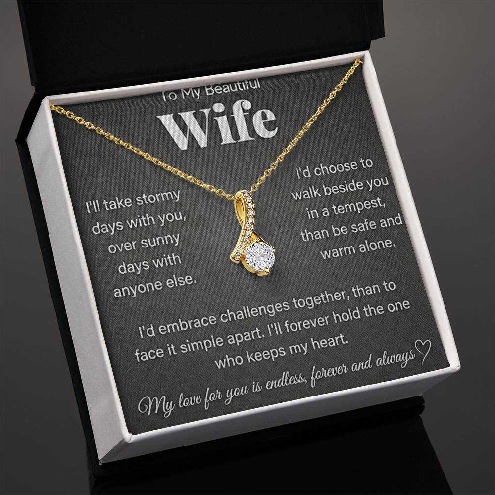 Angled open black presentation box showing a gold-tone necklace and wife message card