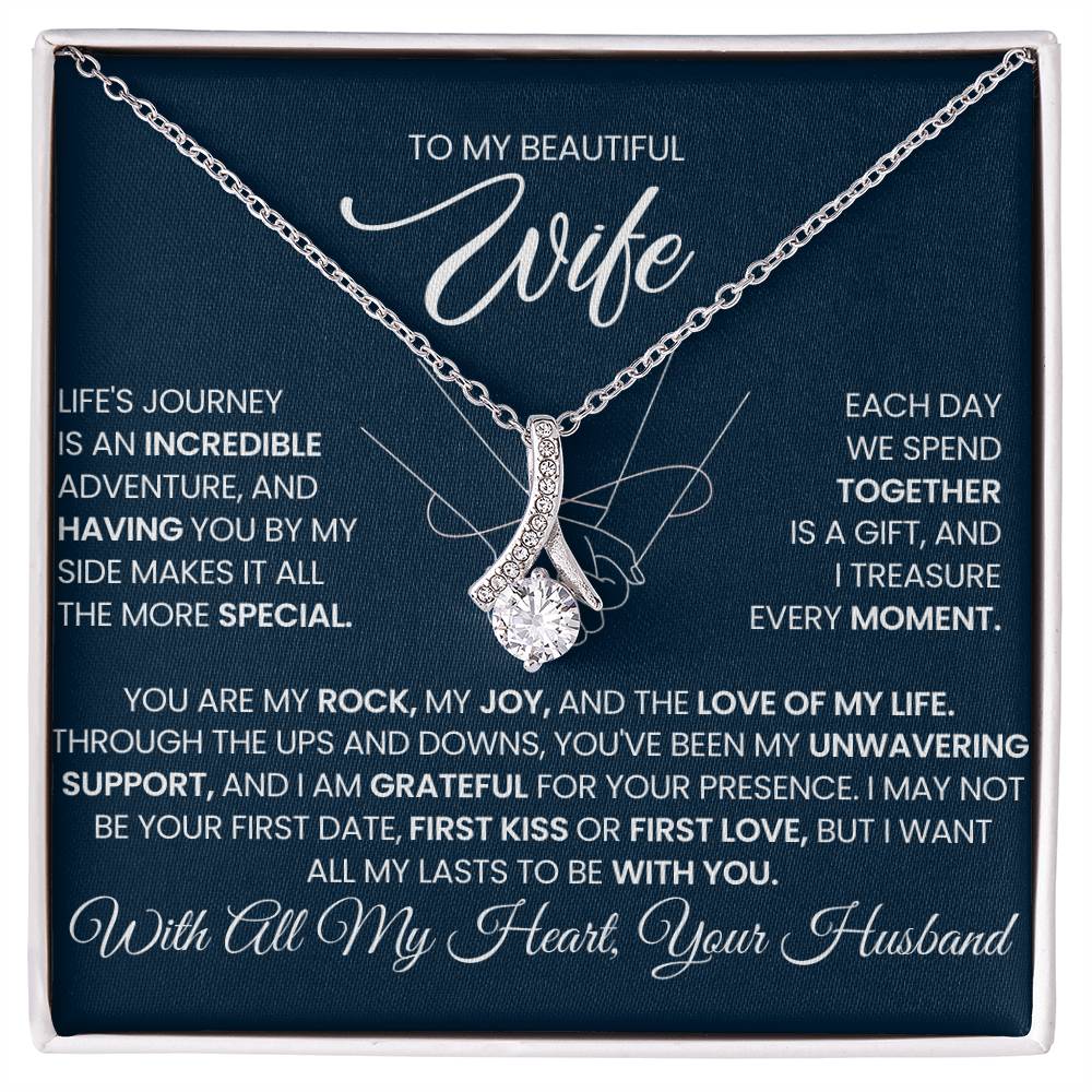 Silver-tone ribbon pendant necklace displayed on a navy message card in a white box