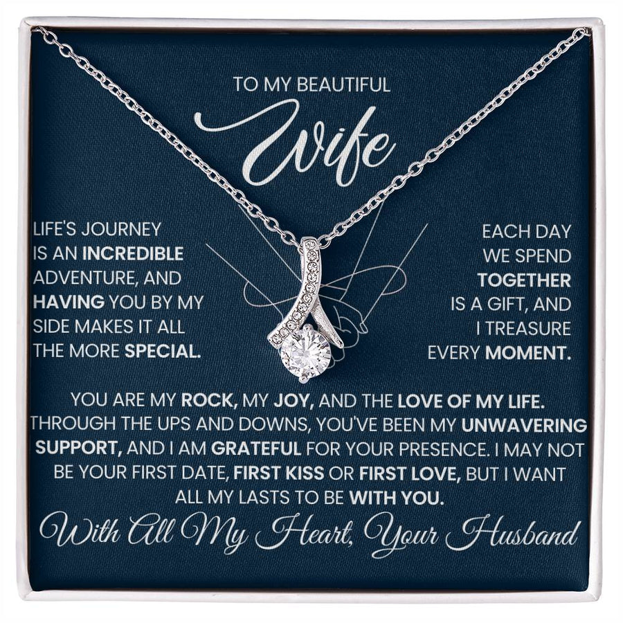 Silver-tone ribbon pendant necklace displayed on a navy message card in a white box