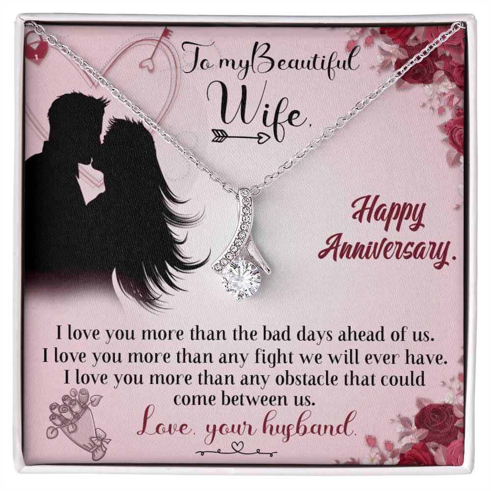 Silver-tone ribbon pendant necklace displayed on a pink anniversary message card for a wife.