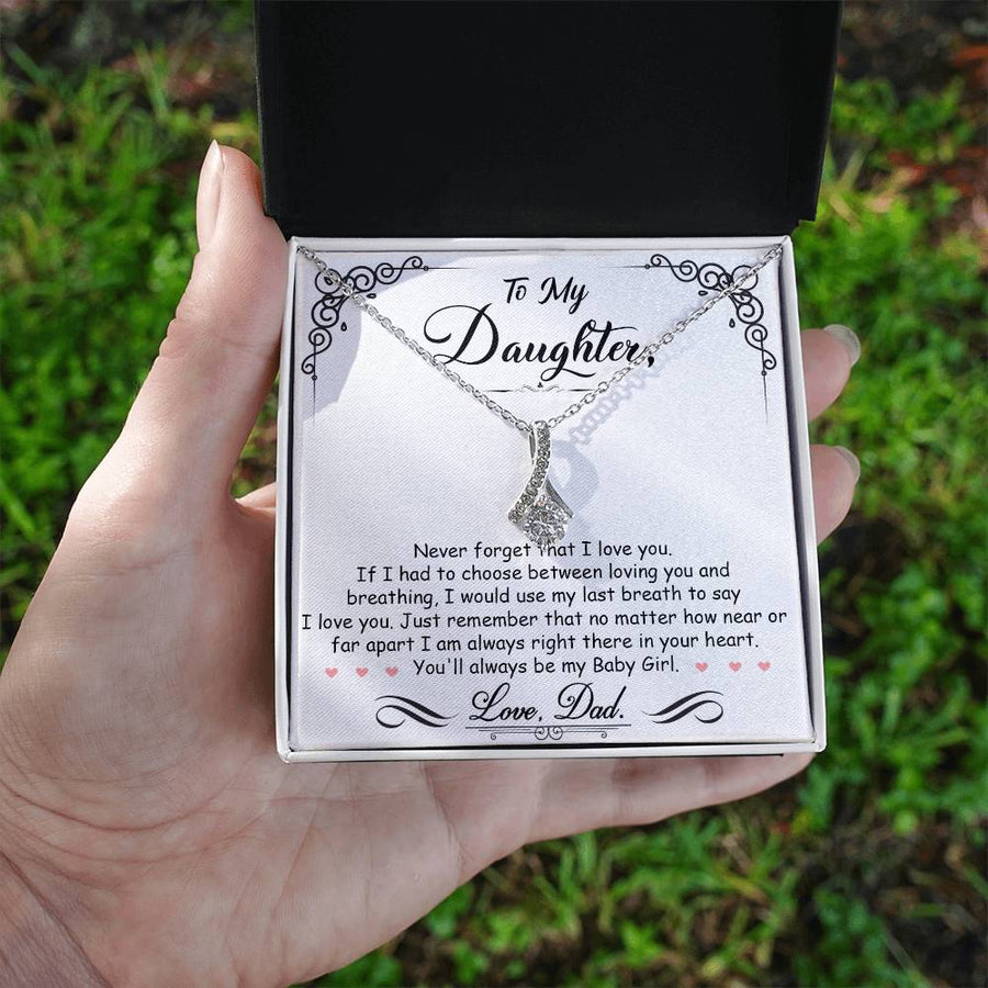 Silver daughter message necklace presented in an open box held outdoors