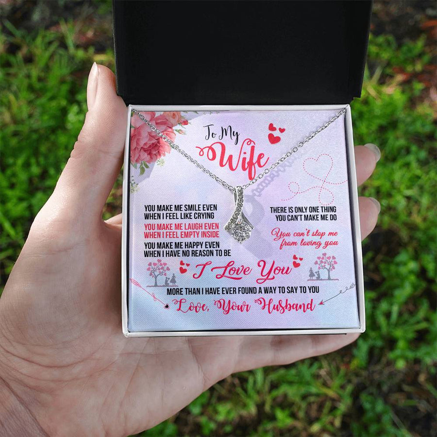 Hand holding an open black jewellery box with the To My Wife necklace and message card