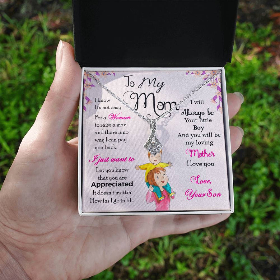 A hand holds an open black jewellery box containing a silver necklace and a message card for Mum.