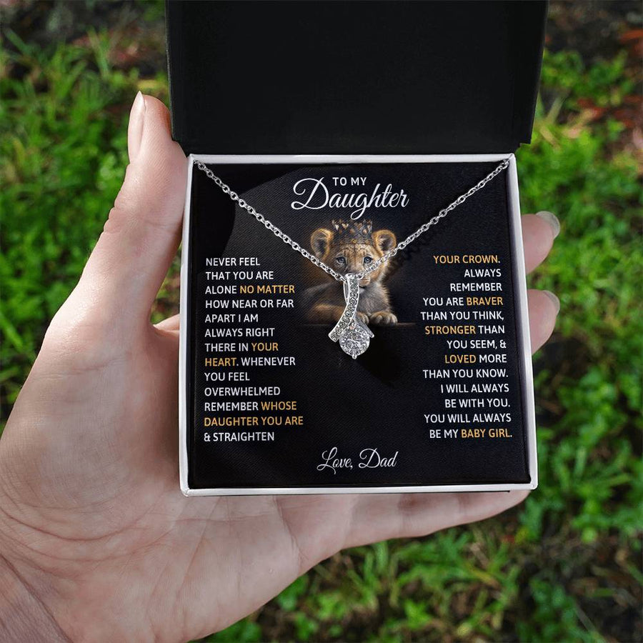 Hand holding an open box with a silver necklace and daughter message card