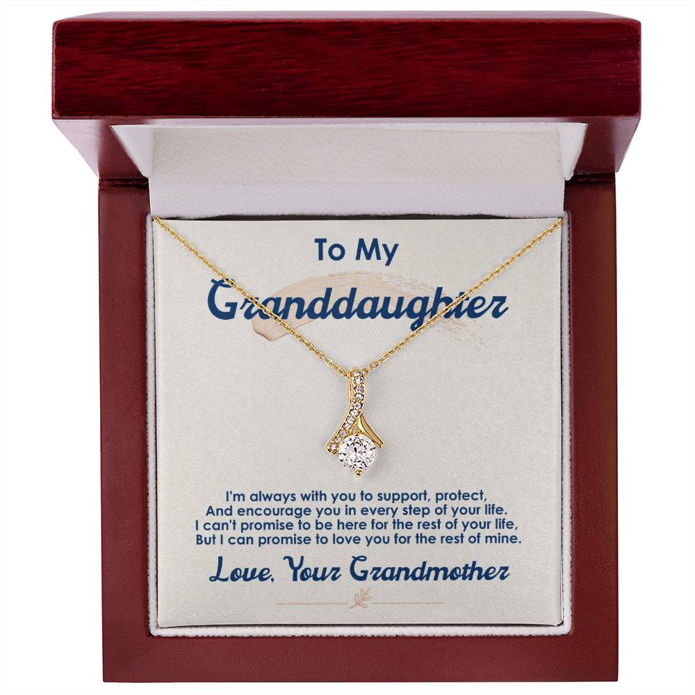 Gold-tone pendant necklace shown in a red wooden presentation box with a message card.