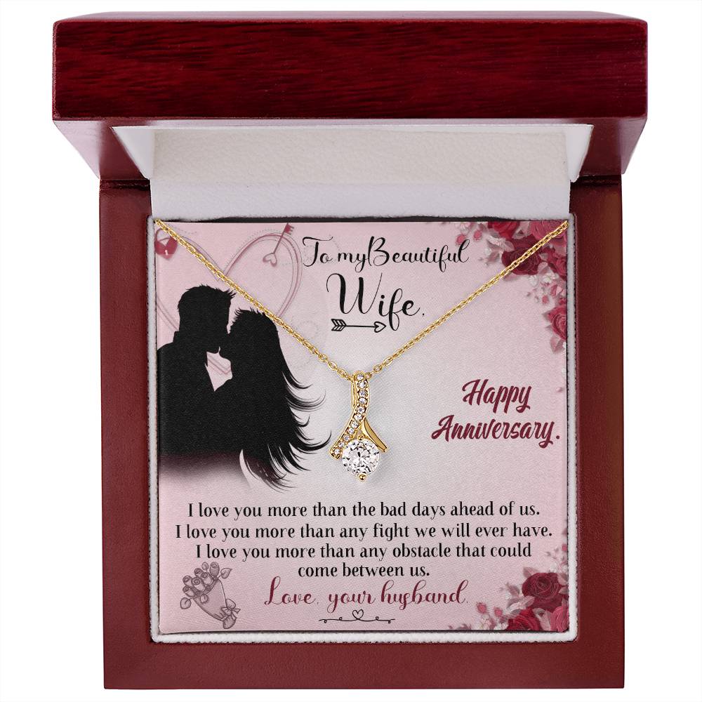 Gold-tone ribbon pendant necklace and anniversary message card displayed in an open mahogany-style box.