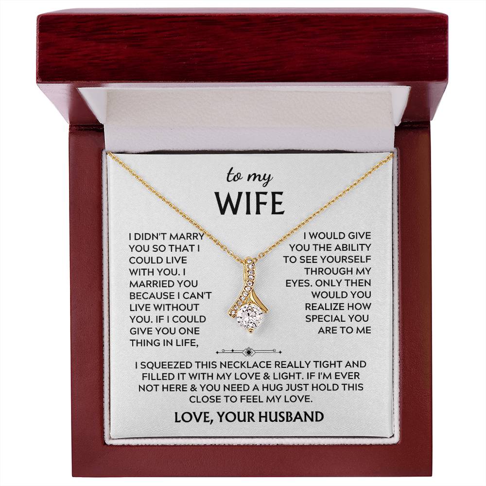 Gold-tone ribbon pendant necklace and wife message card in an open mahogany-coloured box.