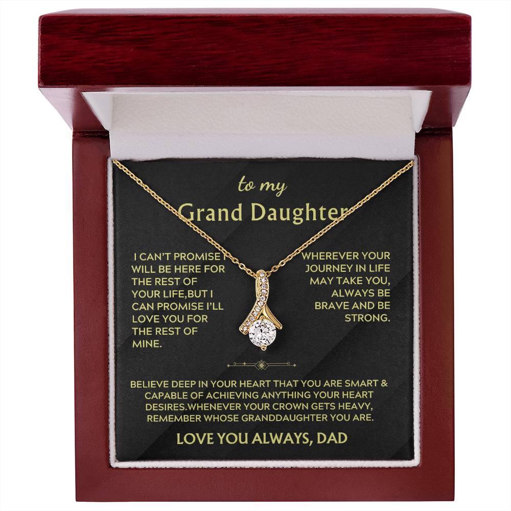 Gold ribbon pendant and granddaughter message card displayed in an open mahogany-style box.