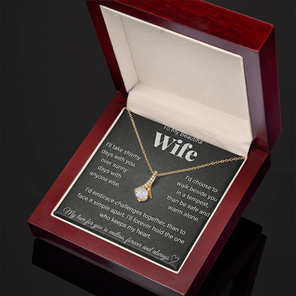 Angled open red wooden box showing a gold-tone necklace and wife message card