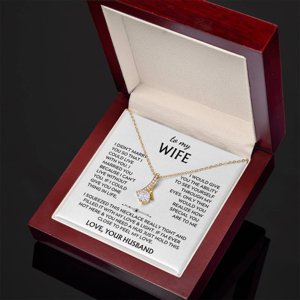 Angled view of a gold-tone necklace and wife message card inside an open presentation box.