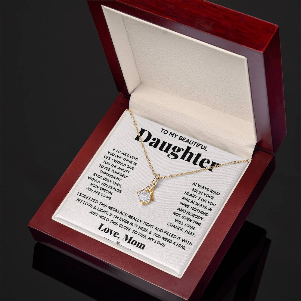 Open red presentation box showing a gold necklace and daughter message card