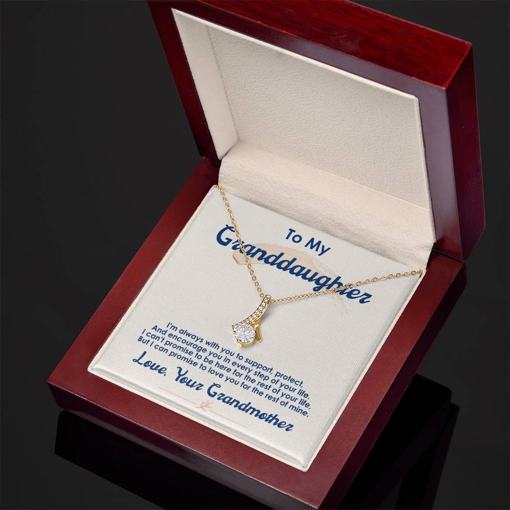 Open red presentation box displaying a gold-tone pendant necklace and granddaughter message card.
