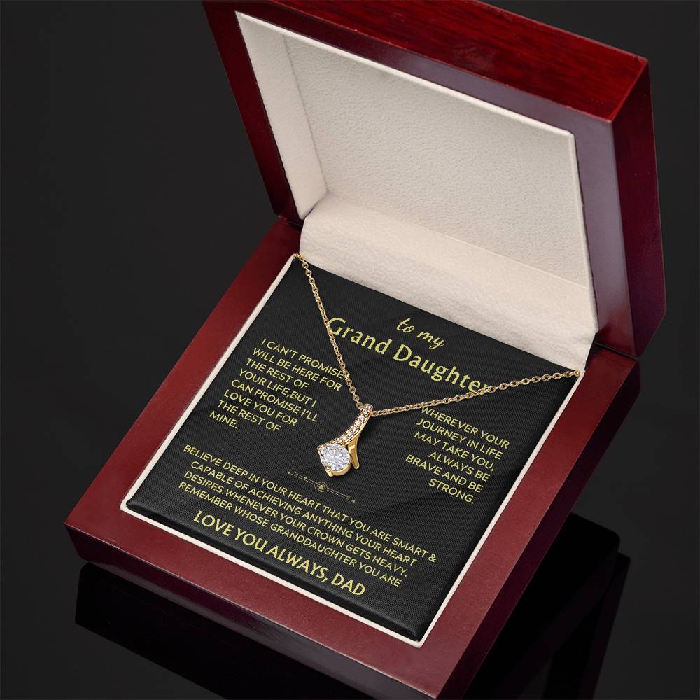 Angled view of a gold ribbon pendant necklace and its printed granddaughter message card.