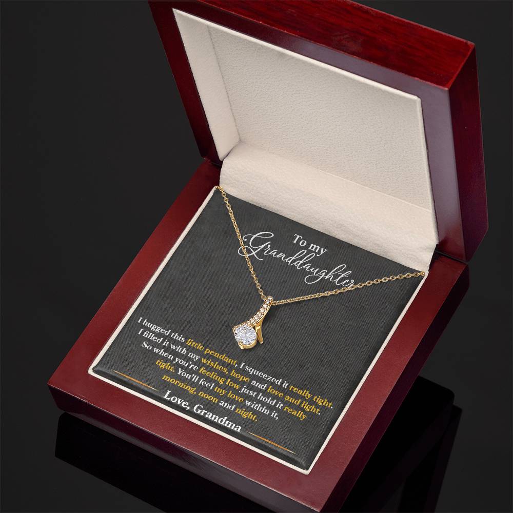 Gold granddaughter message necklace displayed in an open angled jewellery box