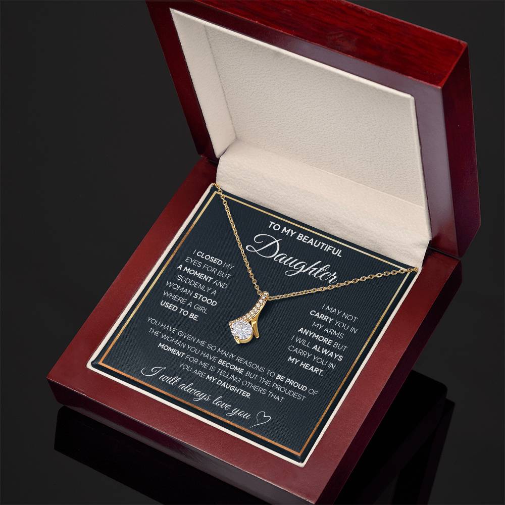 Angled view of a gold-tone ribbon pendant necklace and daughter message card in an open mahogany box