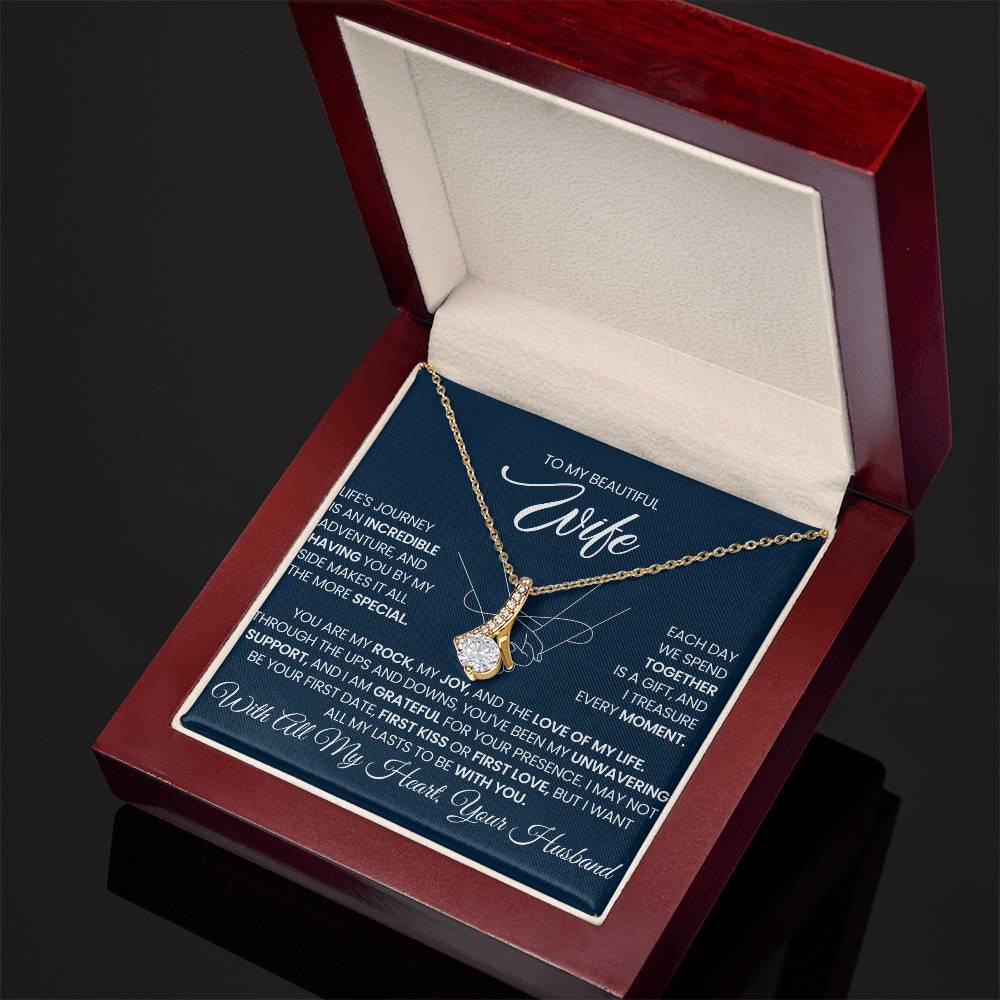 Angled open red gift box displaying a gold-tone necklace and wife message card