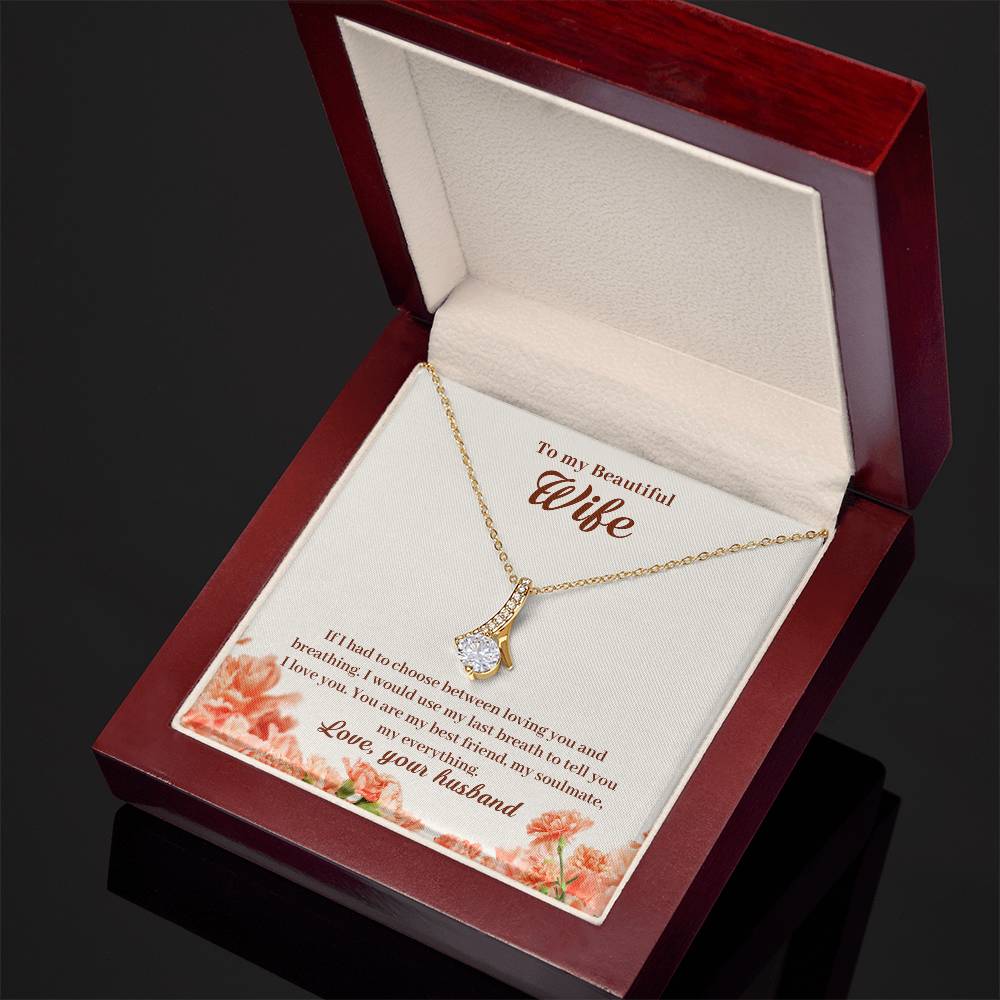 Open angled mahogany jewellery box showing a gold-tone pendant and wife message card.