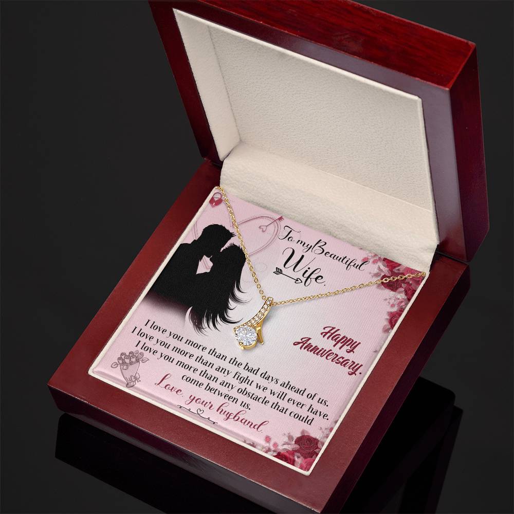 Angled view of a gold-tone ribbon pendant necklace and anniversary card in a mahogany-style box.