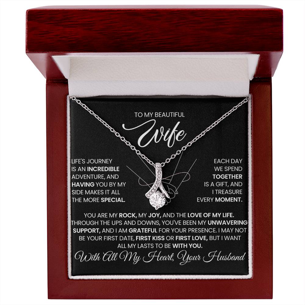 Silver-tone ribbon pendant necklace displayed in a red luxury presentation box.