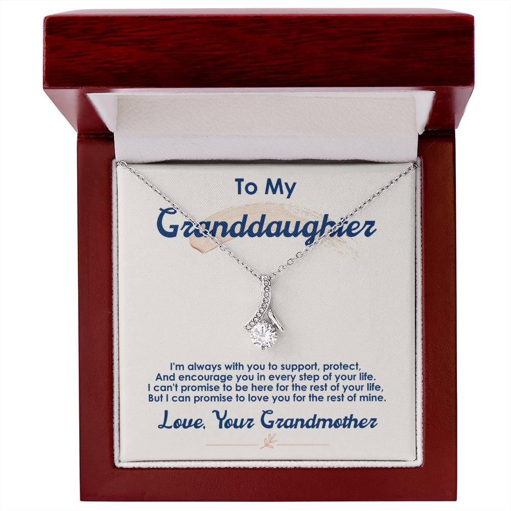 Silver-tone pendant necklace displayed inside a red wooden presentation box.