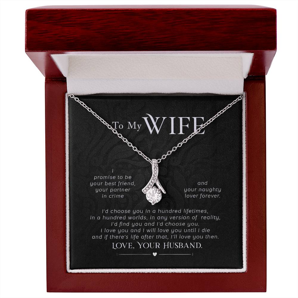 Silver-tone ribbon pendant necklace presented in an open mahogany-style box.