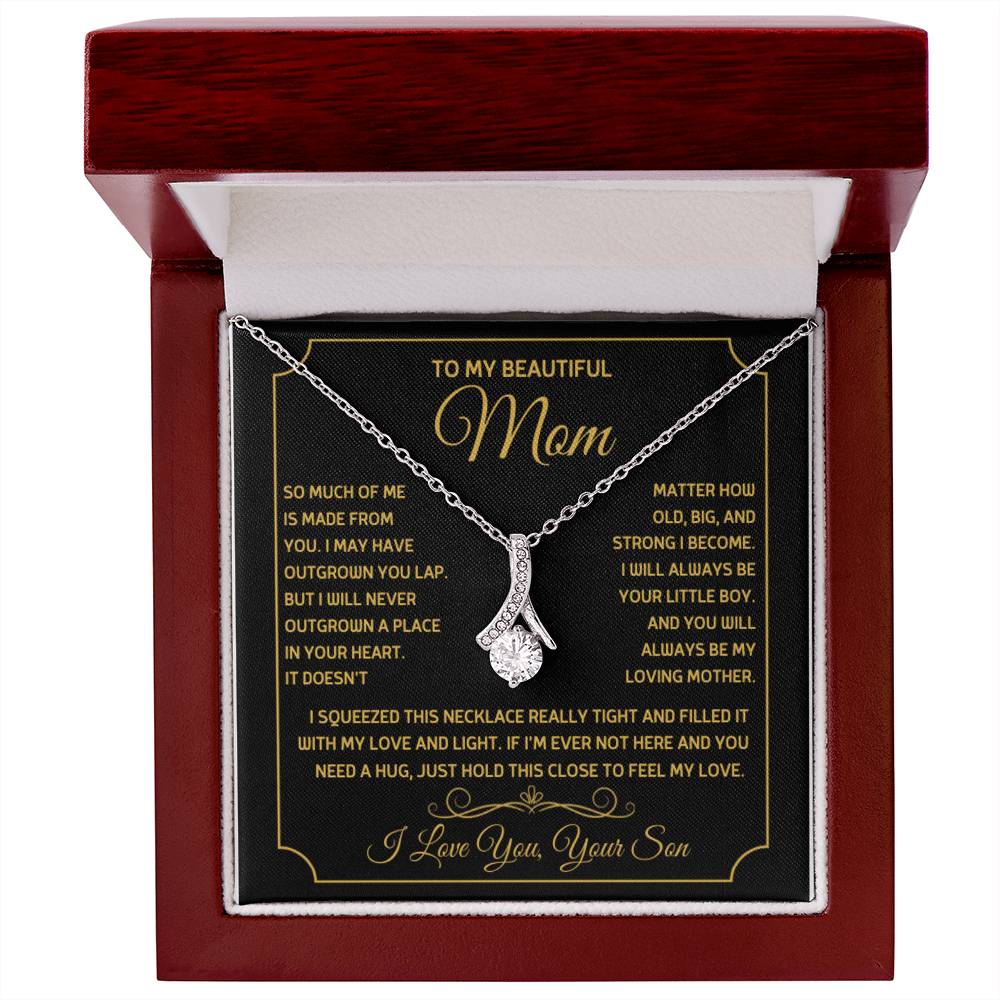 Silver ribbon pendant necklace displayed on a message card in a mahogany box