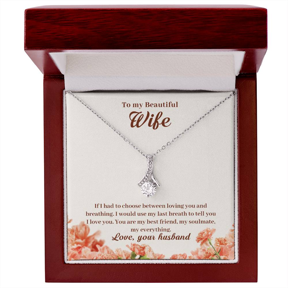 Mahogany jewellery box displaying a silver-tone pendant and message card for a wife.
