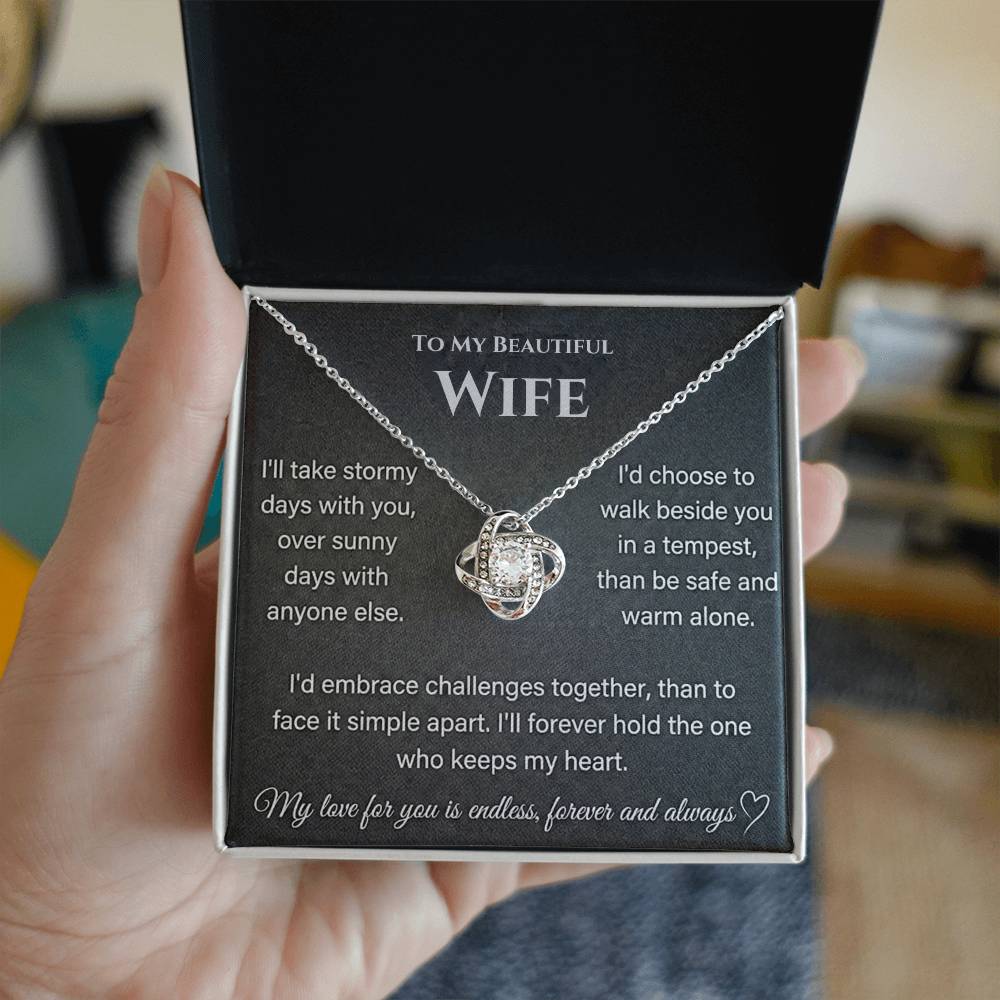 Silver Love Knot Necklace in an open jewellery box held by a hand