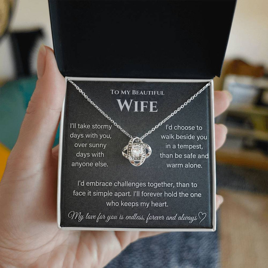 Silver Love Knot Necklace in an open jewellery box held by a hand