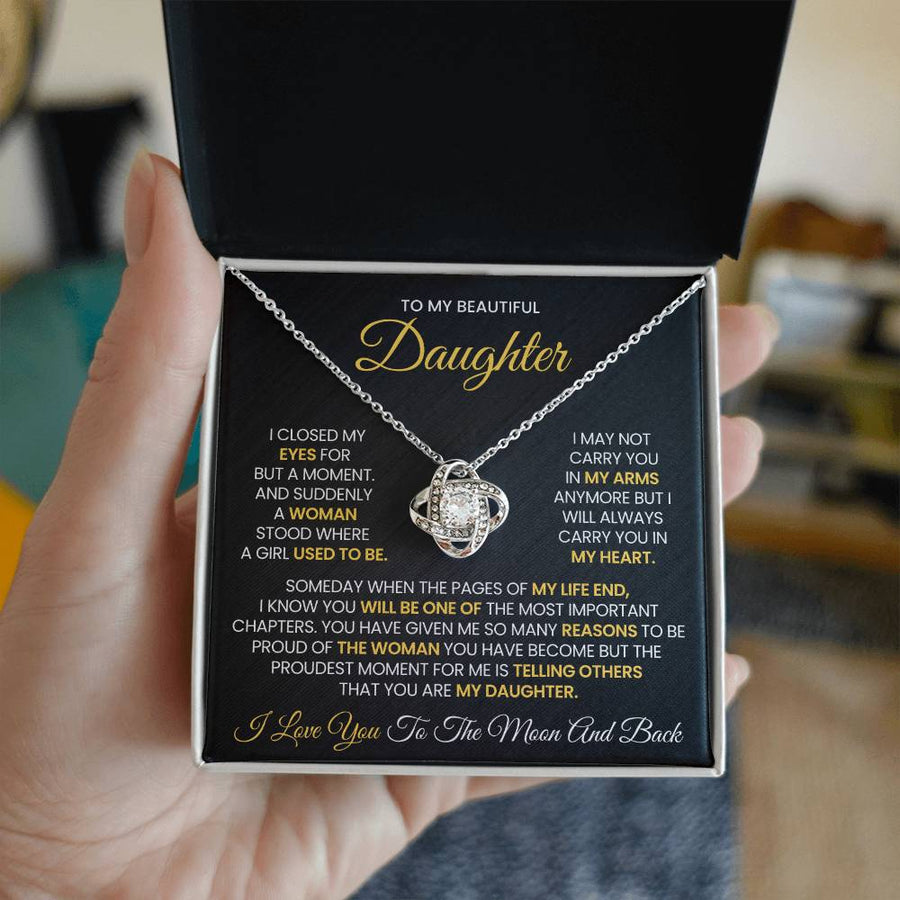 Open jewellery box held in a hand, showing the daughter message card and silver-tone necklace