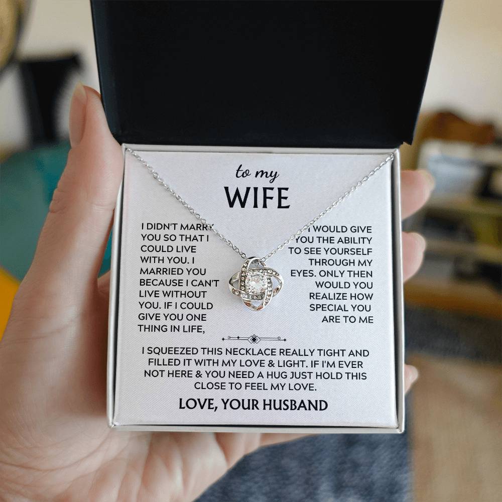 Silver Love Knot necklace and message card held in an open black presentation box