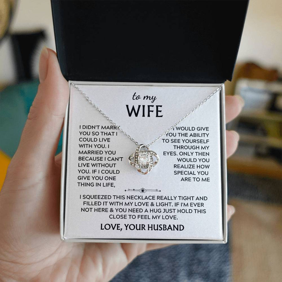 Silver Love Knot necklace and message card held in an open black presentation box