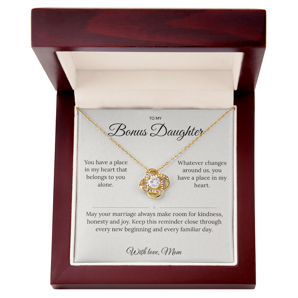 Gold Love Knot necklace and bonus daughter message card inside an open mahogany-style jewellery box