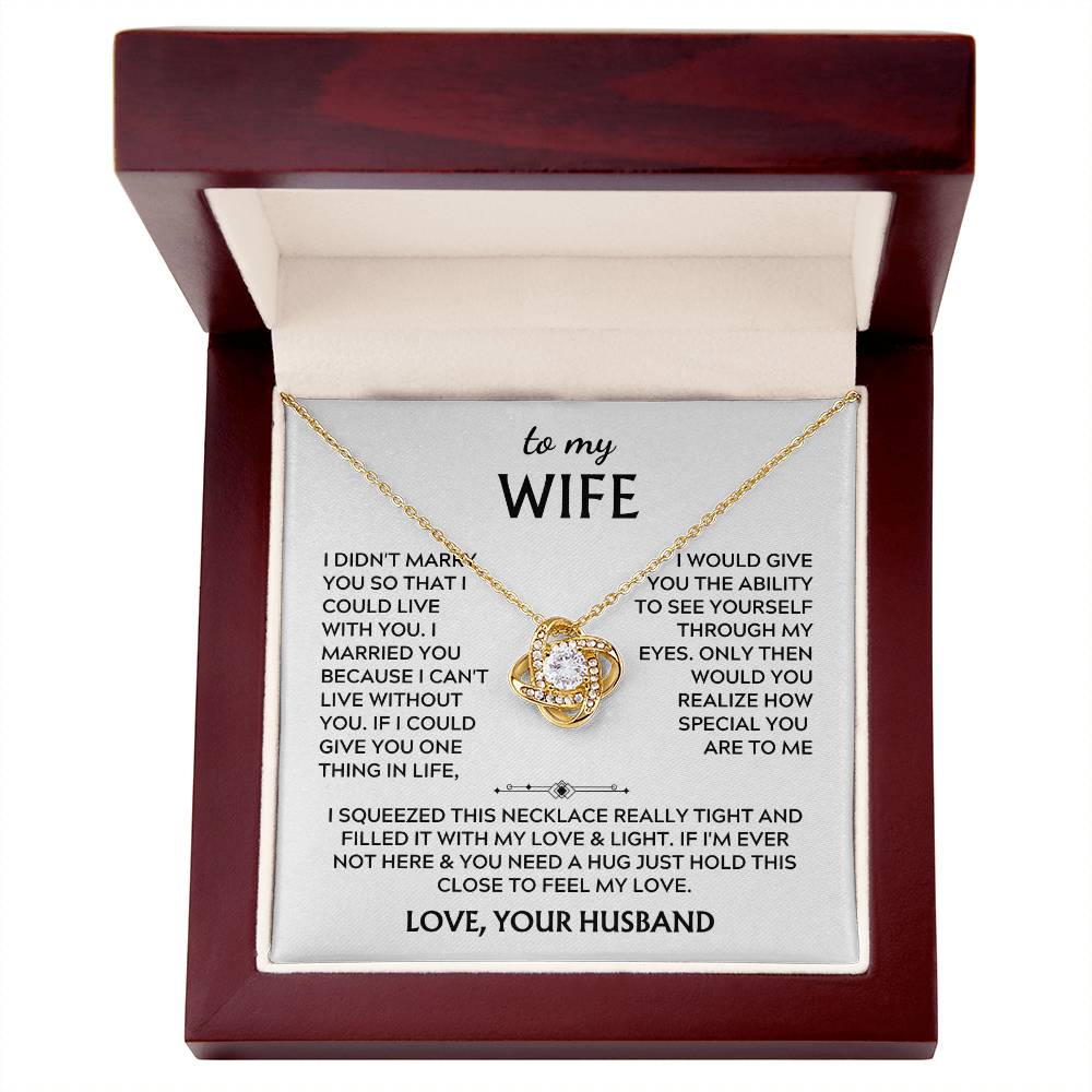Gold Love Knot necklace and message card inside an open mahogany presentation box