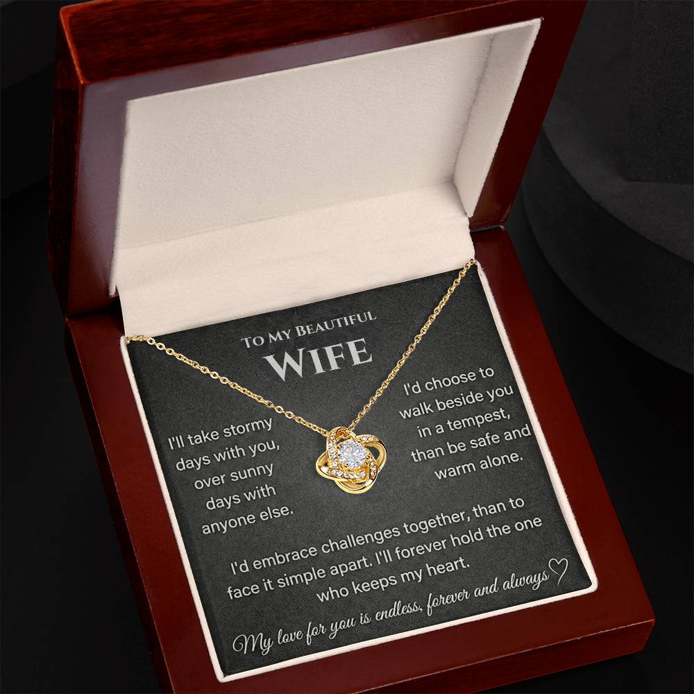 Gold Love Knot Necklace displayed at an angle in an open mahogany-style box