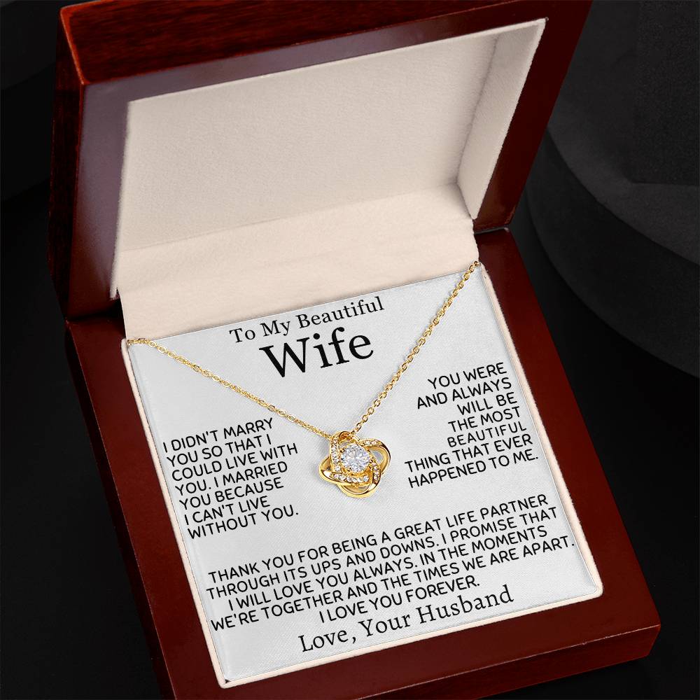 Angled view of a gold Love Knot Necklace and wife message card in a mahogany box