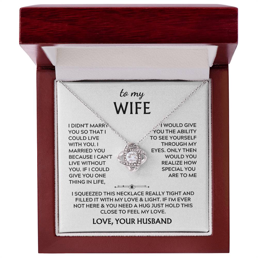 Silver Love Knot necklace and message card inside an open mahogany presentation box