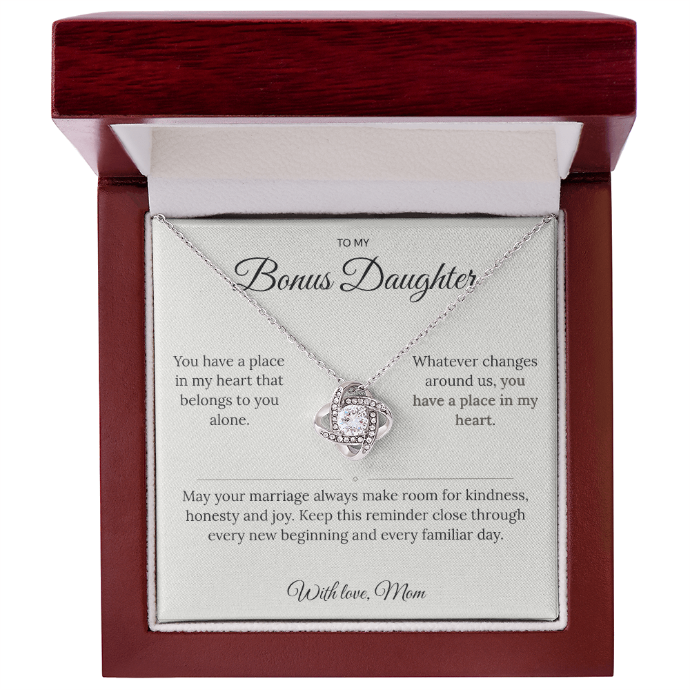 Silver Love Knot necklace and message card presented inside an open mahogany-style jewellery box