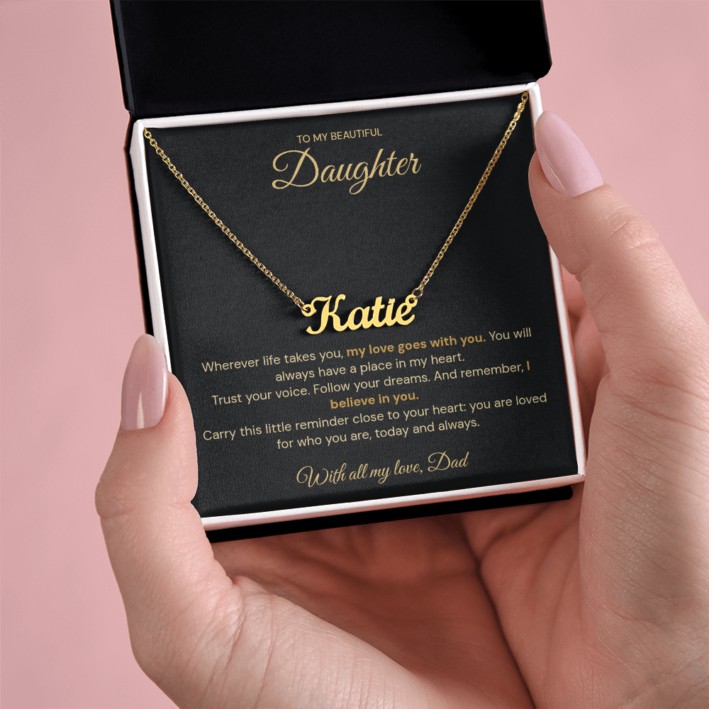 Open jewellery box held in one hand, displaying a gold-coloured Katie name necklace