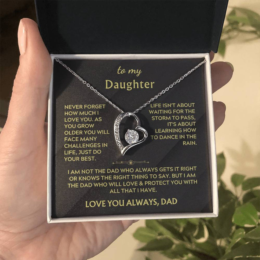Hand holding a heart-shaped crystal necklace in its white presentation box