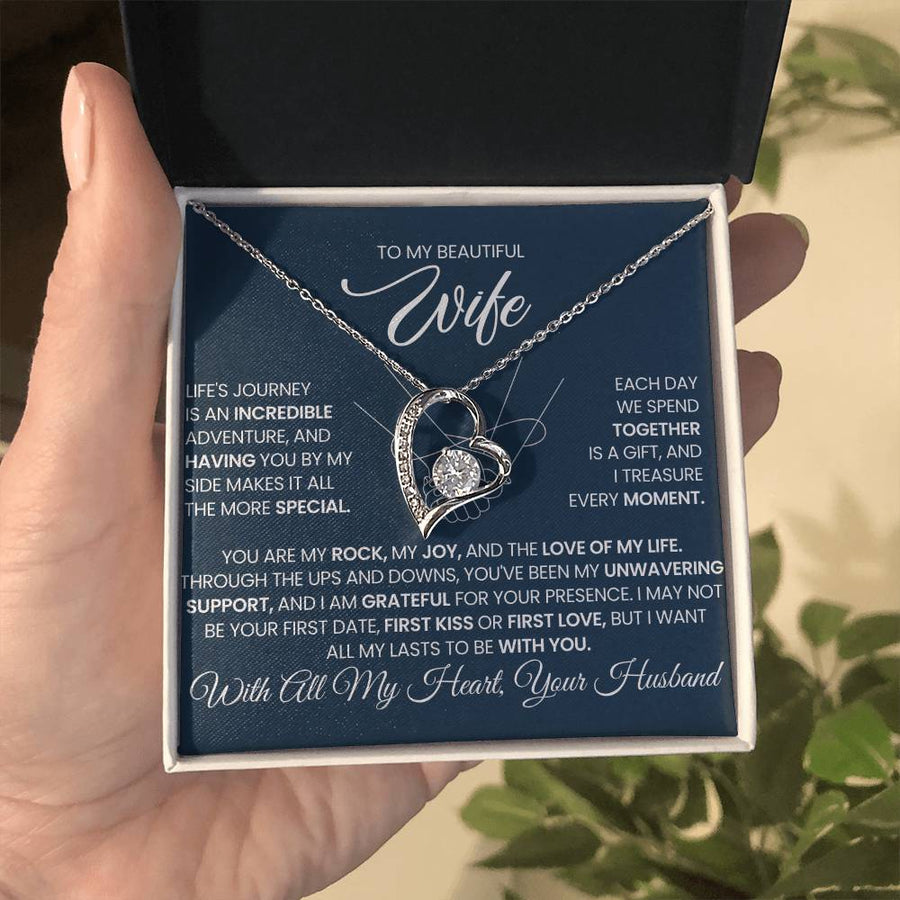 Open jewellery box held in a hand, showing a wife message card and silver heart necklace