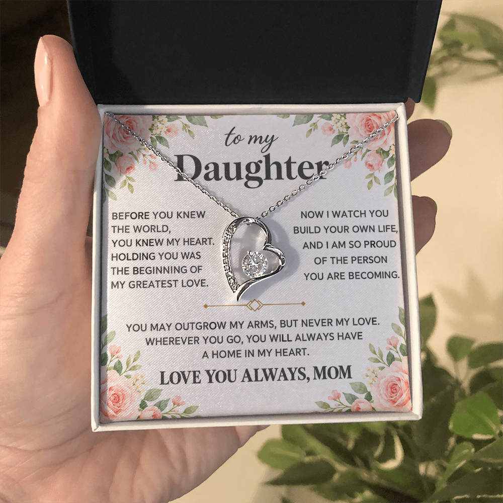 Heart pendant necklace shown on a floral Daughter message card held in a hand outdoors.