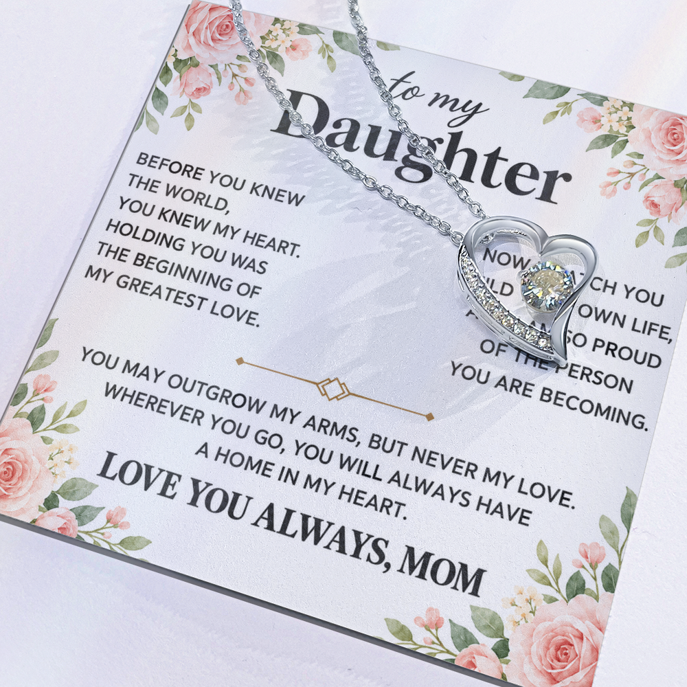 Close-up of a heart pendant necklace resting across a floral Daughter message card.